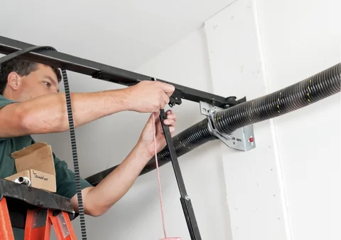 Technician performing garage door spring repair in Montreal