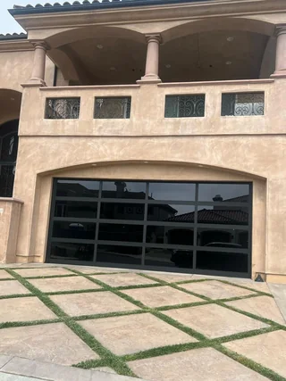 Black glass garage door on a stucco home