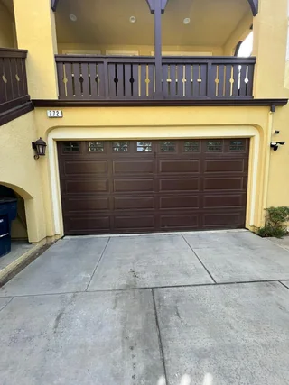Brown carriage-style garage door with top windows