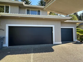 Black double and single garage doors after installation