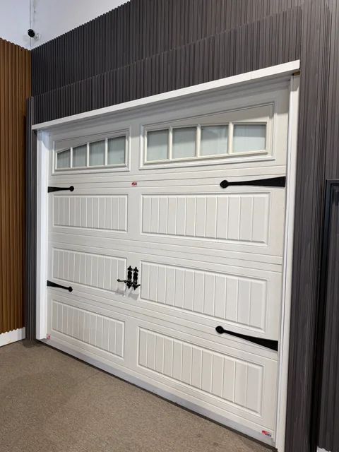 Classic white carriage-style garage door with windows