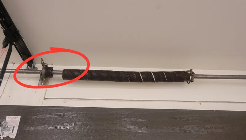 Broken garage door torsion spring above the door