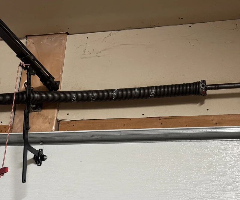 Torsion spring system mounted above a garage door